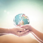 World environment day concept: Human hands holding earth global on blurred nature background. Elements of this image furnished by NASA.