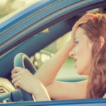 Side view window portrait displeased young stressed angry pissed off woman driving car