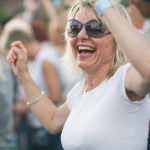 Cheerful woman enjoying at Noc na Vrhniki music concert.