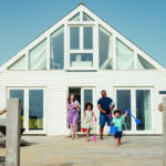 Young multi-ethnic family walking outdoors at beach house